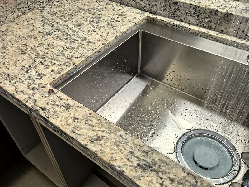 천연석 상판 부분교체 후 사각싱크볼에 물을 틀어 테스트하는 모습