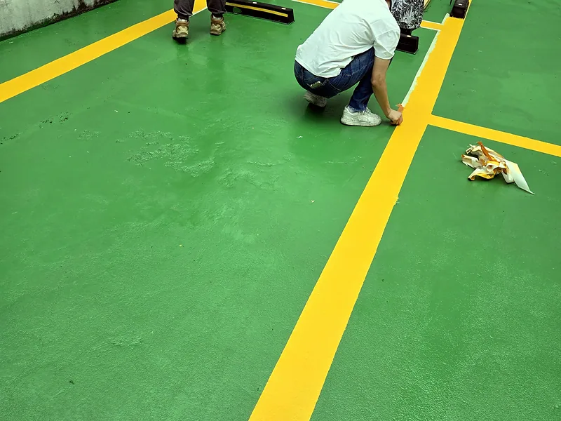 주차장 도색 중 주차라인 경계를 다듬는 작업