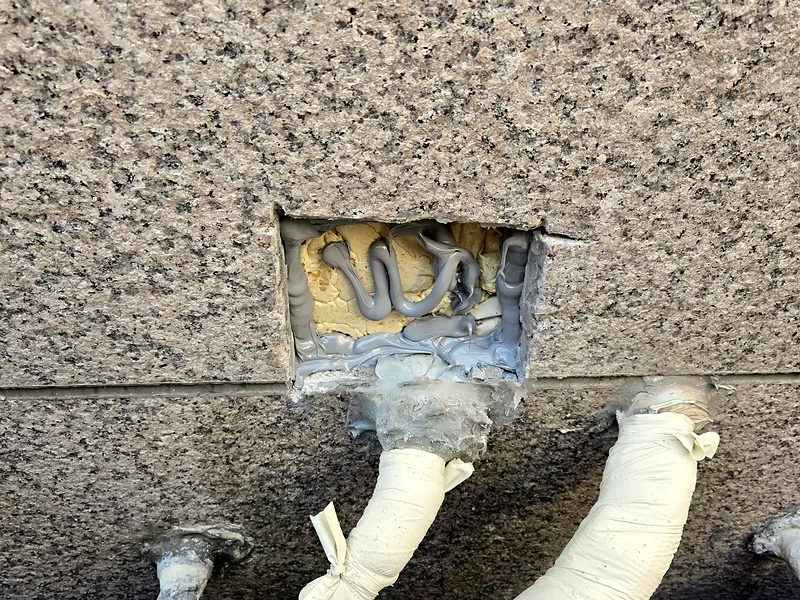 대리석 외벽 배관 구멍 주변을 사각으로 따낸 복원 전 단계