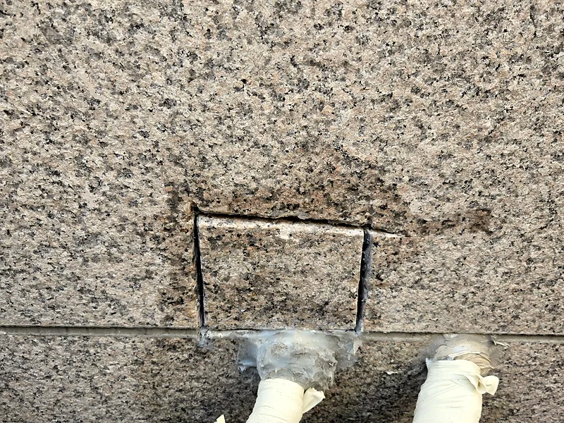 대리석 외벽 배관 구멍 자리에 석재 조각을 끼운 모습