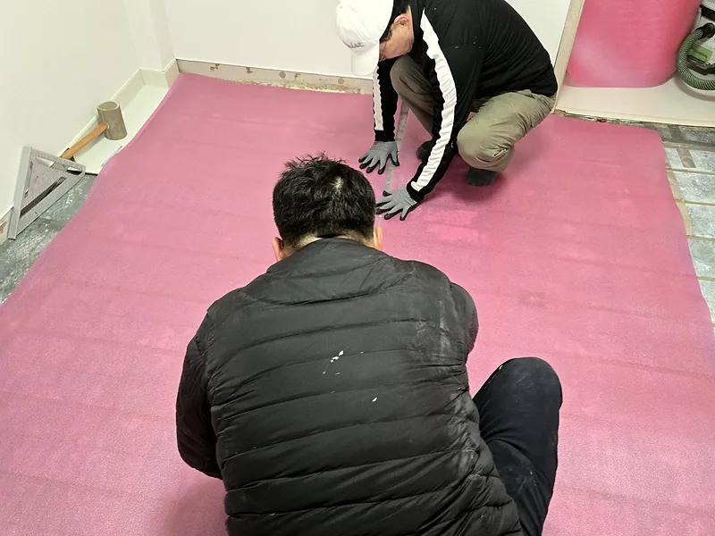 강화마루 부분 교체를 위해 기술자들이 하부 완충재를 정리하는 작업