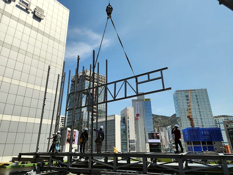 건물 옥상 전광판 설치 중 크레인으로 들어 올린 철골 트러스