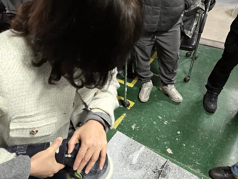 싱크대 수리 교육생이 강사 지도 아래 상판 가장자리를 연마하는 모습