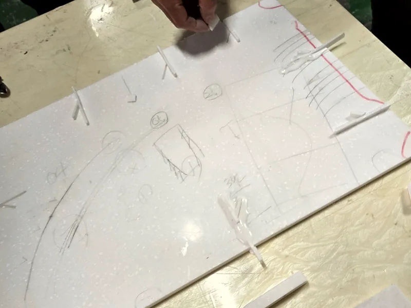 인조대리석 실습 전 재단선과 보수 위치를 연필로 표시한 판재