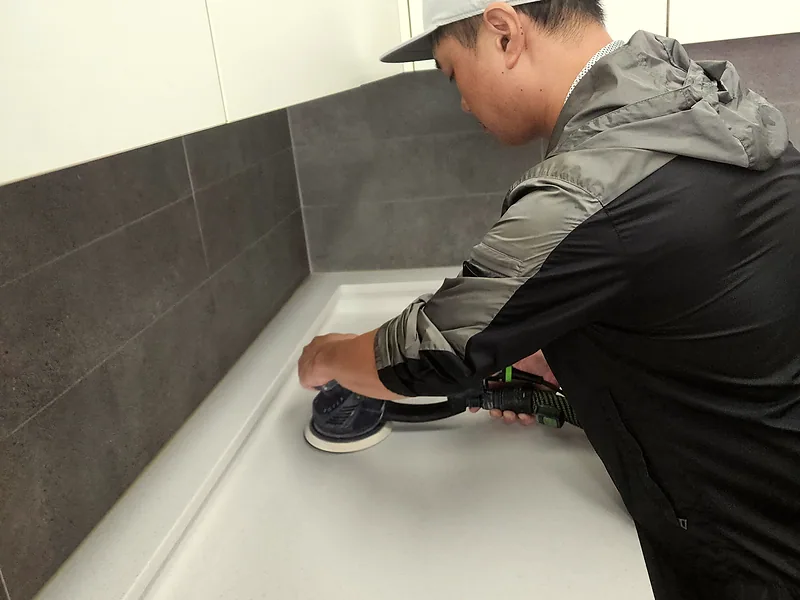 기술자가 샌더로 디귿자 싱크대 상판을 연마하는 작업 과정