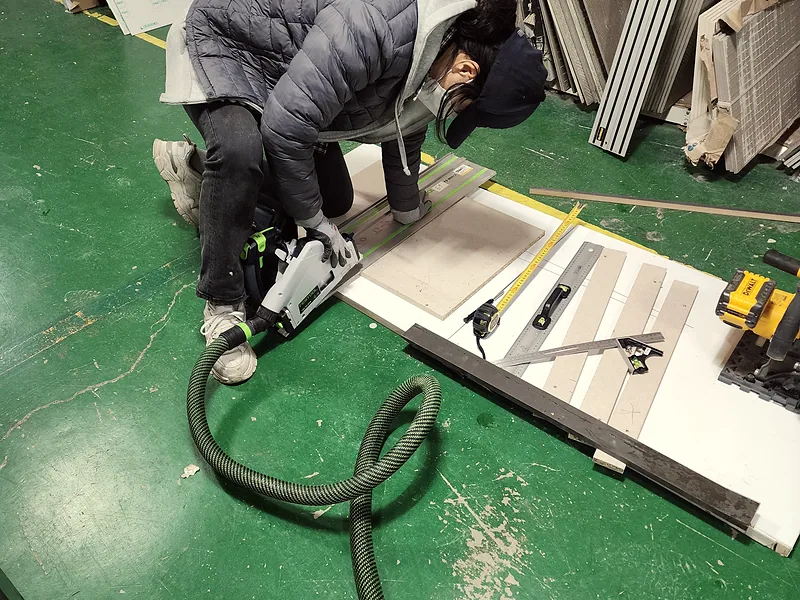 교육장 바닥에서 레일 절단기로 인조대리석 상판을 자르는 집수리 기술교육 실습