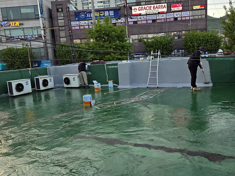 옥상 누수 보수 현장 난간 벽체에 방수층을 도포하는 작업