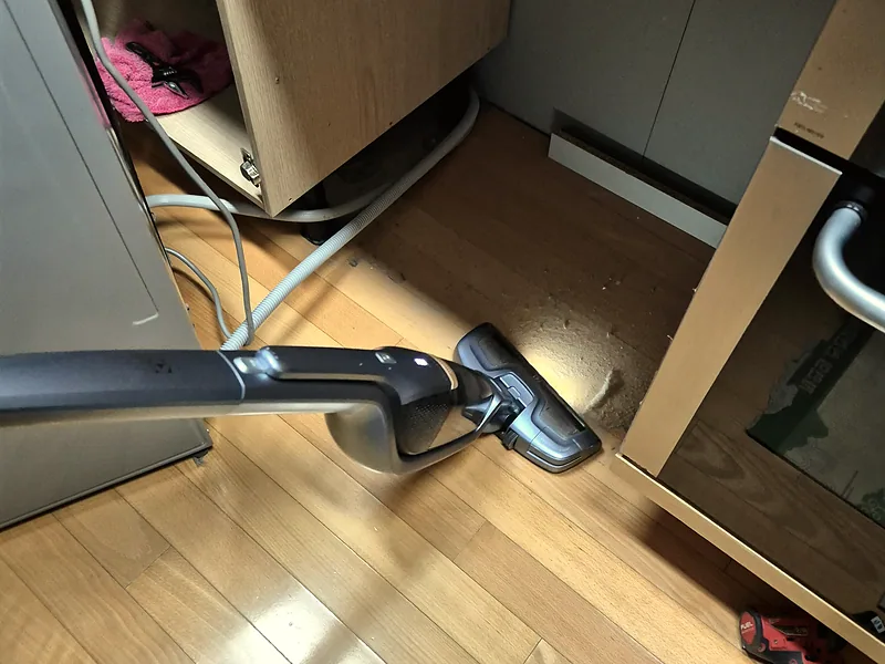싱크대 서랍장 설치 전 하부장 바닥 먼지를 청소기로 정리하는 작업
