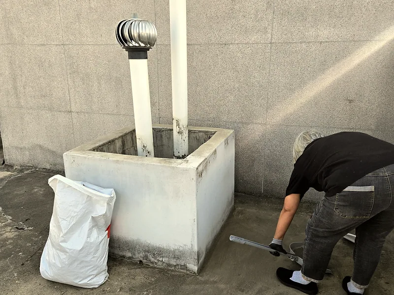 옥상 환풍기 하우징 철거 잔해를 정리하는 작업자