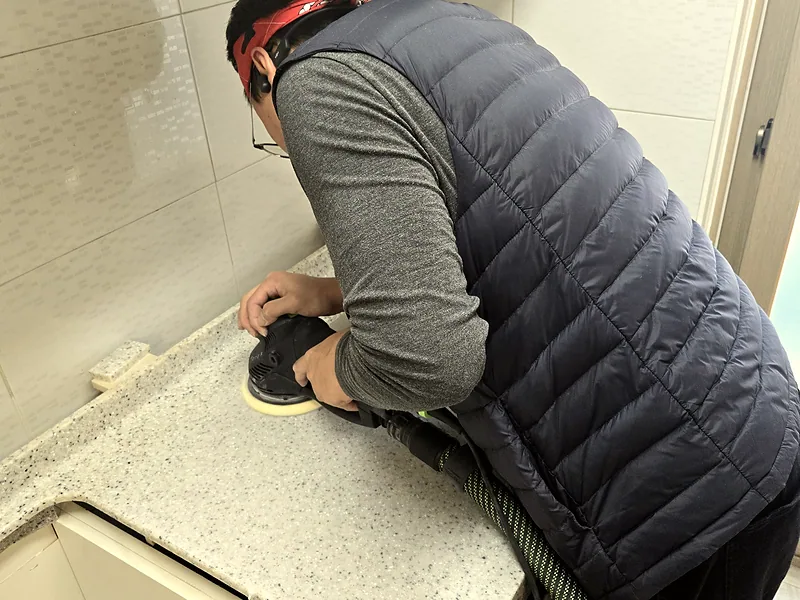 싱크대 상판 균열 연마 작업 중인 기술자